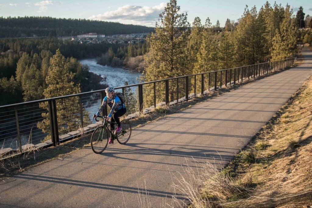 Person biking on the Centennial Trail that runs alongside the Spokane River.