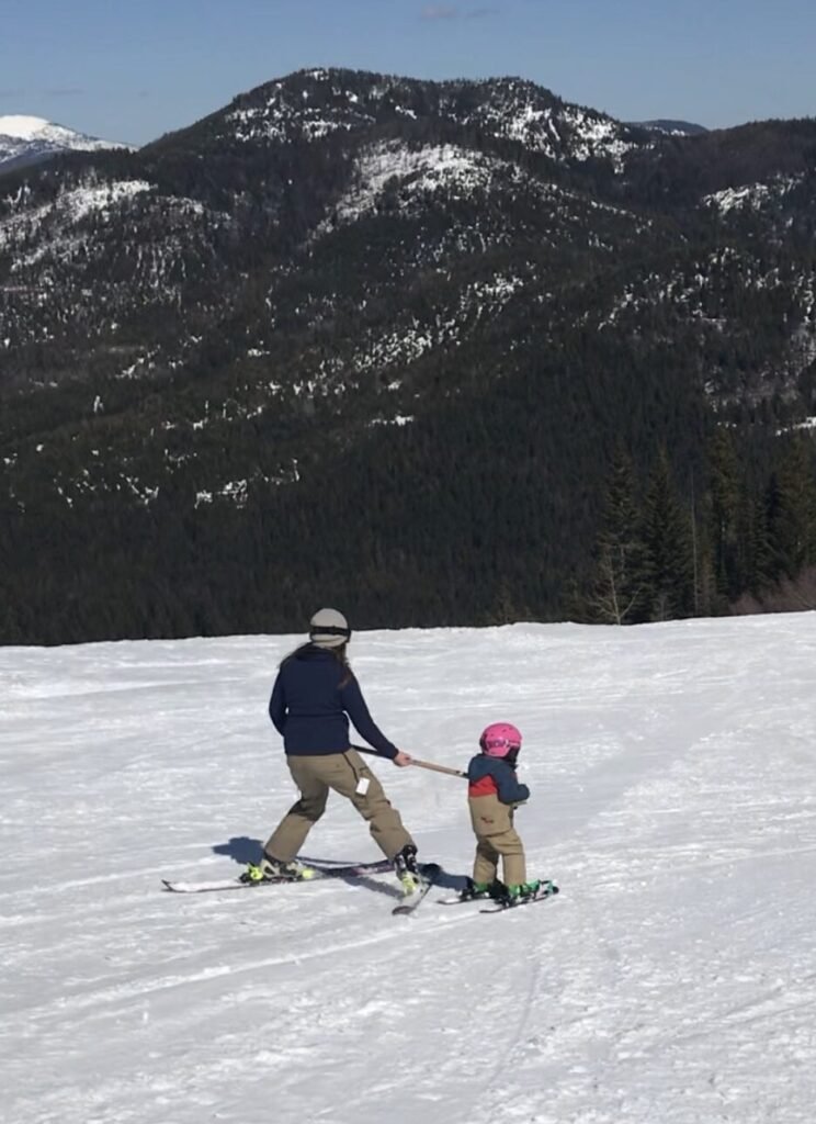 Mother teaching daughter to ski at 49 degrees north.