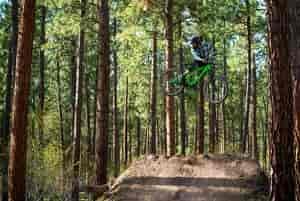 Mountain biker getting massive high air off a jump.