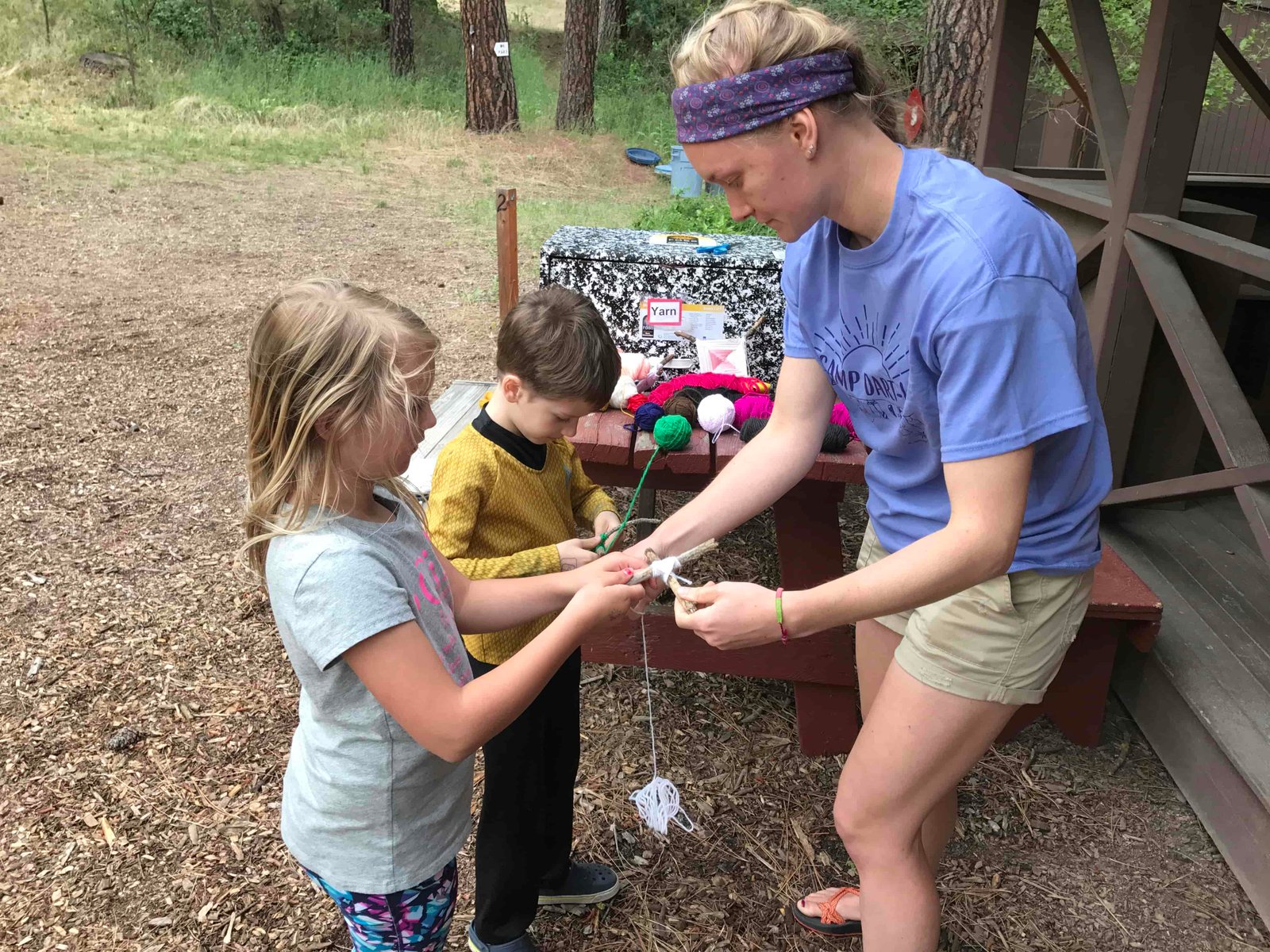 A camp leader helps a camper make a traditional God's Eye craft (Photo: Camp Fire Inland Northwest)