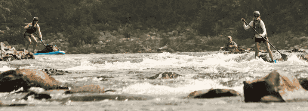 Photo of paddleboarders navigating rapids on the Spokane River.