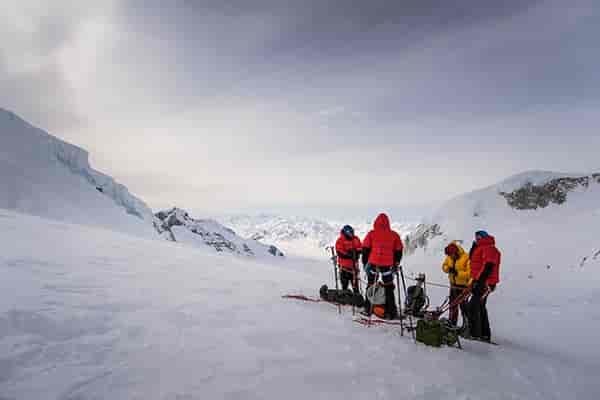 Photo of teams members huddled in group on Mount Kennedy.