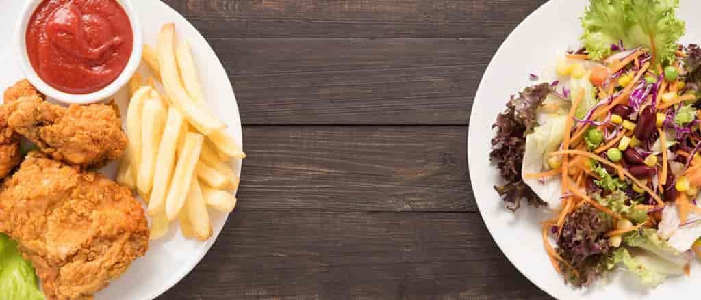 Photo of plate of chicken and fries versus plate of salad.