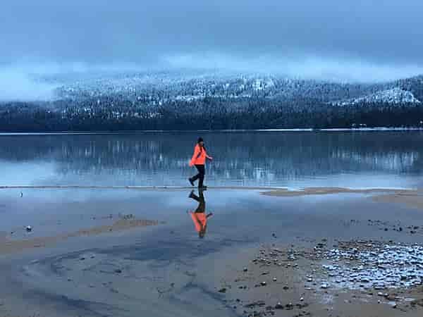 Photo of girl running across Priest Lake.