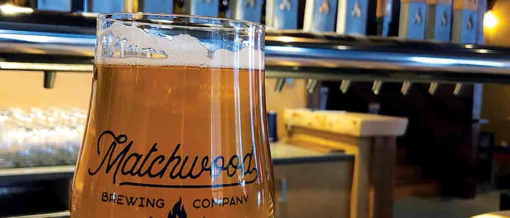 Close up photo of beer with taps in background.