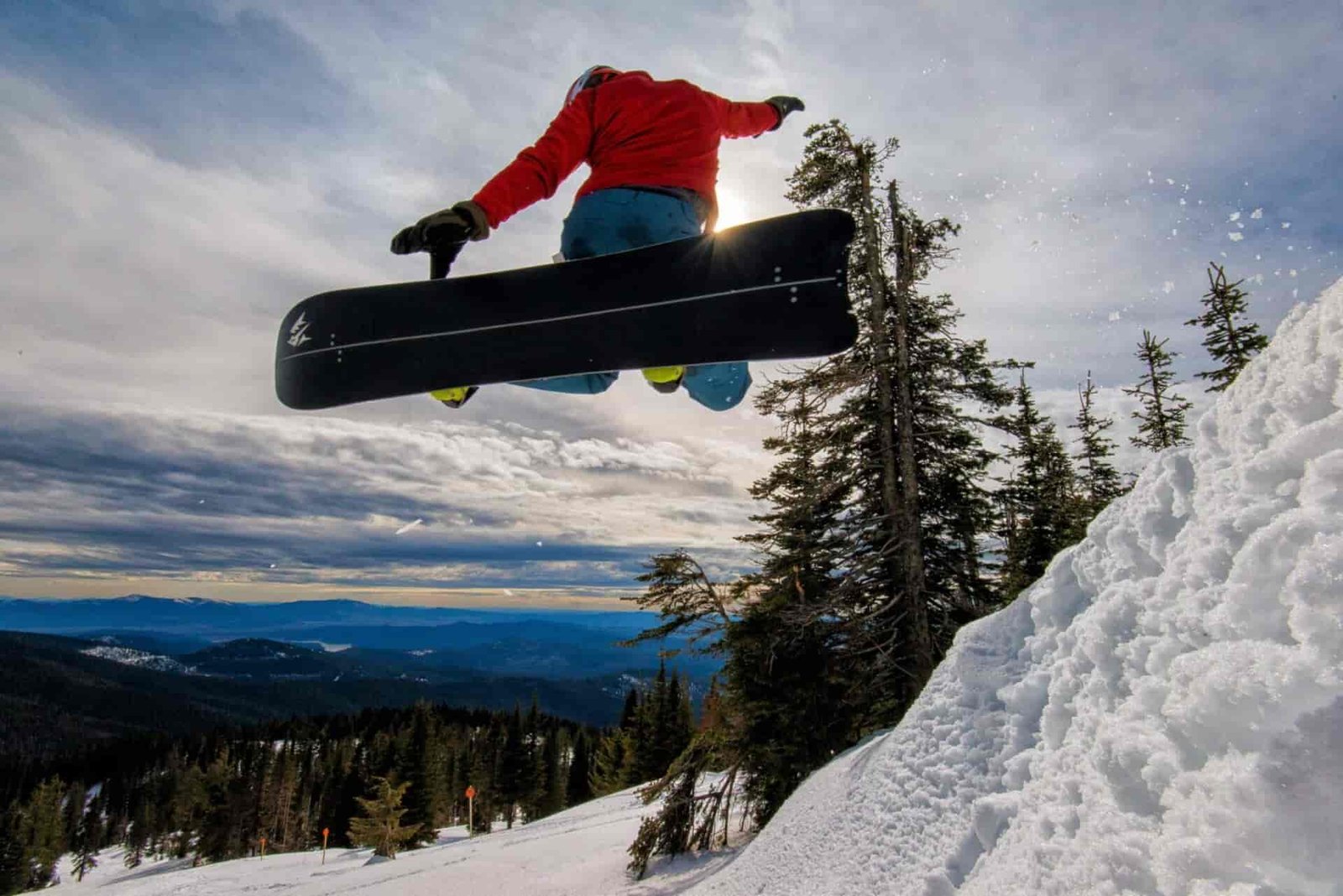 Person jumping off a snowboard jump.
