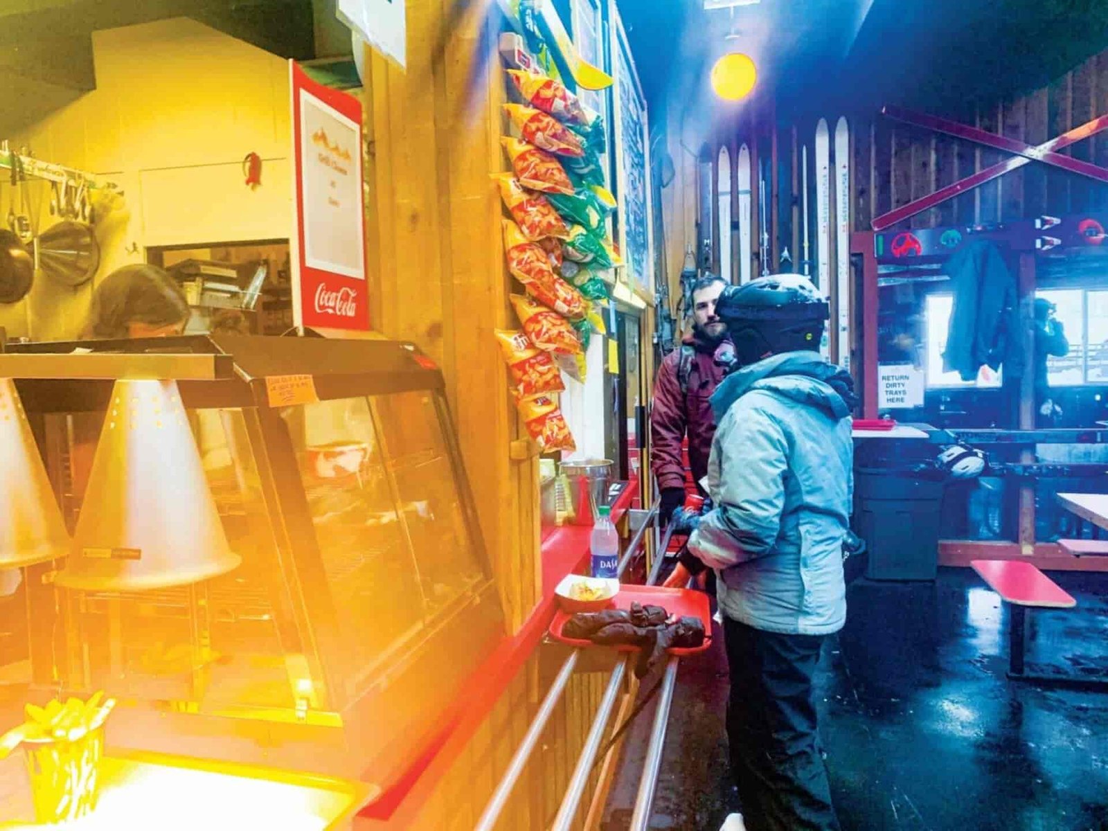 Snowboarder ordering food after snow-boarding.