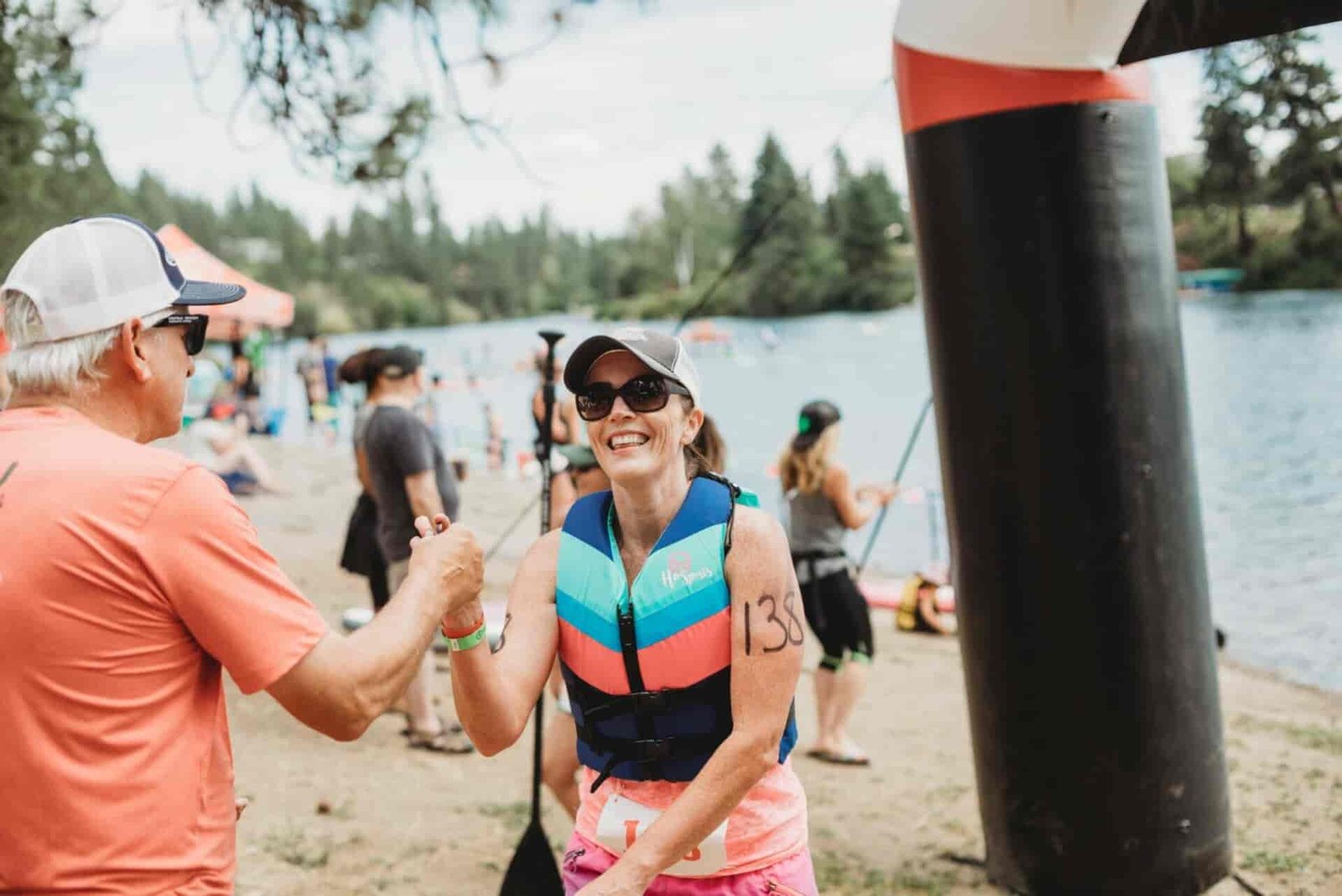 A woman shaking hands with a man after finishing a marathon.