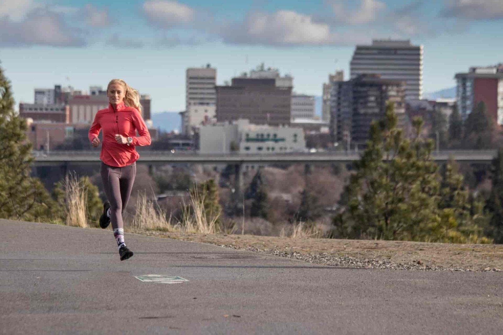 A woman running on a paved trail.