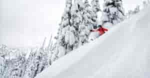 A Rippin Chix skier goes down a steep and deep run.