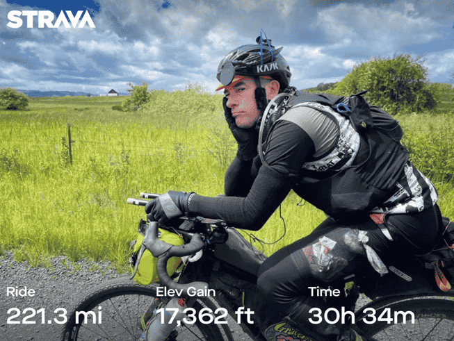 Cyclist Justin Short on his gravel bike looking tired after riding over 200 miles, 30 miles, with over 17,000 feet of elevation gain.